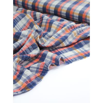 Close-up of Coral Cove Plaid cotton blend seersucker fabric featuring a blue, coral, cream, and yellow plaid design with a subtle silver lurex stripe.