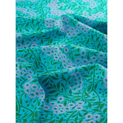 Close-up of Kaffe Fassett X William Morris Cotton Lawn Fabric – Michaelmas Daisy Aqua, featuring delicate daisy motifs in bright blue and soft pinks on finely woven cotton lawn.