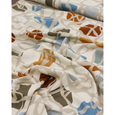 Close-up of 100% viscose twill fabric – Pebble Path print, featuring an abstract design with organic shapes in rust, ochre, olive, blue, and neutrals. Soft, drapey, and perfect for dressmaking.